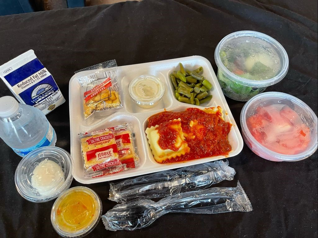 Picture of box lunch for 2020 school year with fruit salad, green salad, and water bottle